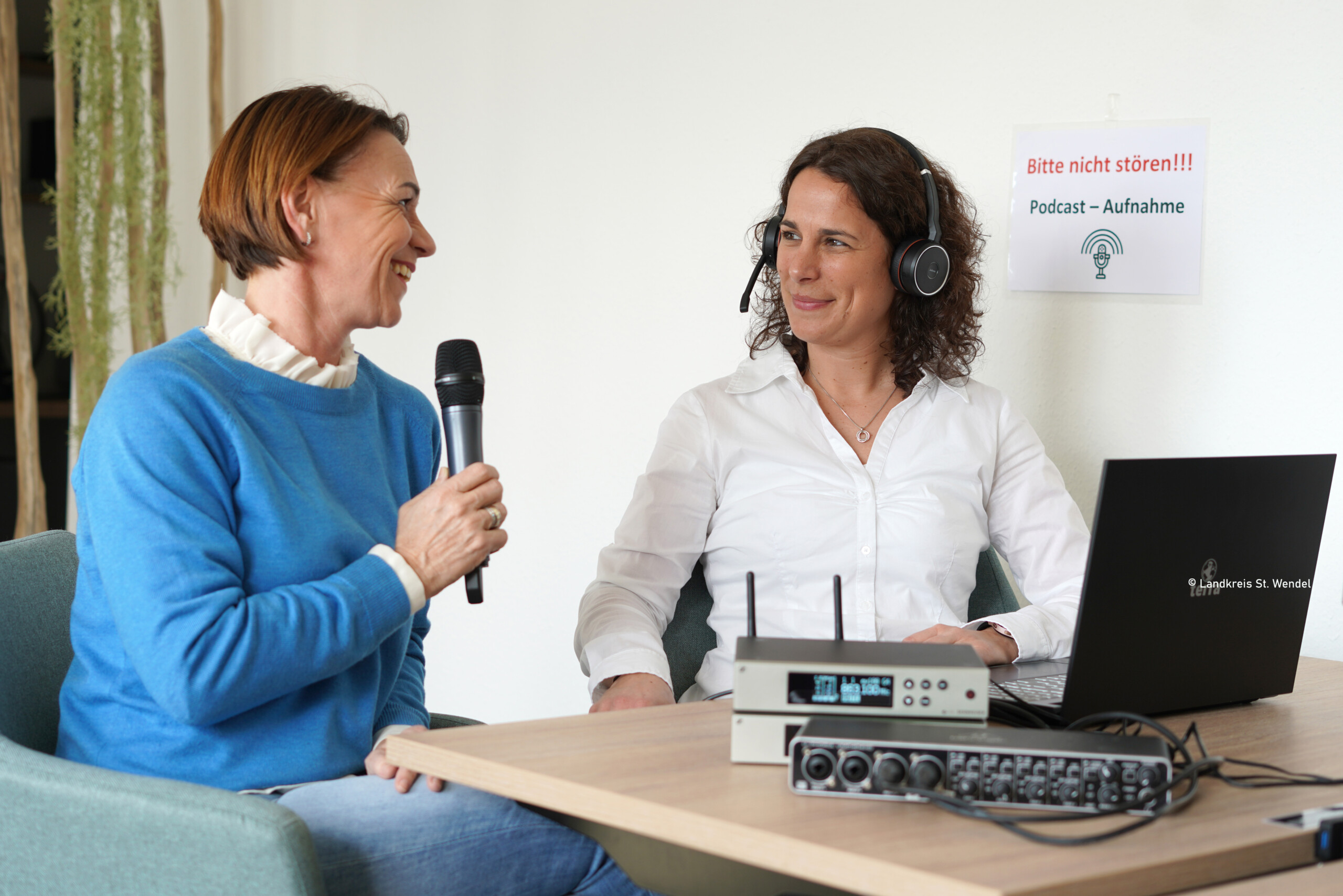Zwei Frauen sitzen sich bei einer Podcast-Aufnahme gegenüber